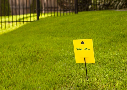 Weed Man sign in green lawn